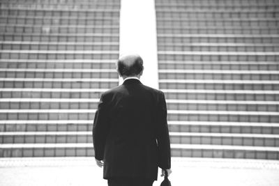 Rear view of man standing in the dark