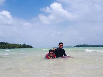 Portrait of couple on beach against sky