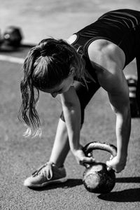 Woman doing exercise with kettlebell in gym