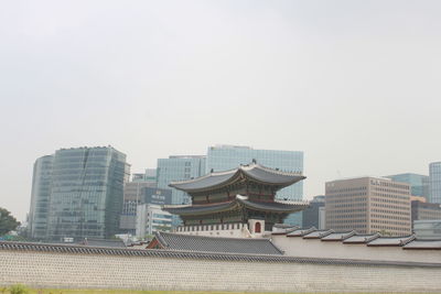 Buildings in city against clear sky