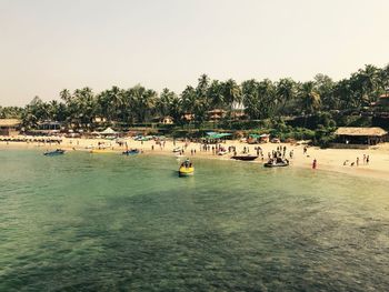 People on beach against clear sky