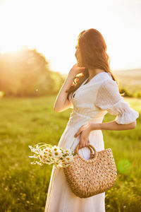 Rear view of young woman standing by plants