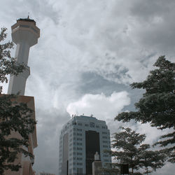 Low angle view of buildings against cloudy sky