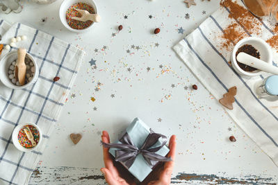 High angle view of hand holding paper on table