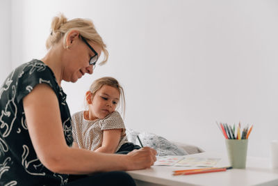 Grandmother helping granddaughter in study at home