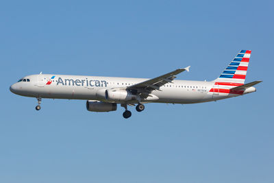 Airplane flying against clear blue sky