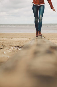 Low section of woman walking on beach