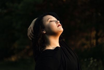 Young woman with eyes closed at night