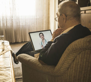 Rear view of man using mobile phone