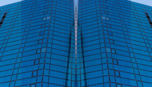 Low angle view of modern building against blue sky