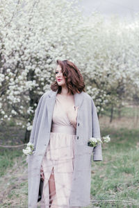 Beautiful girl in a dress walking in a blooming garden