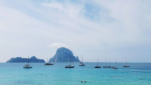 Sailboats in sea against sky