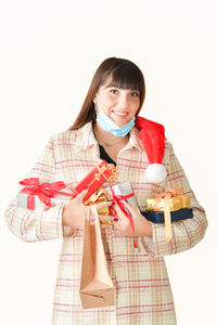 Portrait of smiling young woman standing against white background