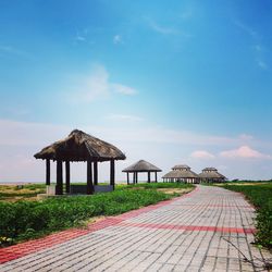 Gazebo on footpath by building against sky