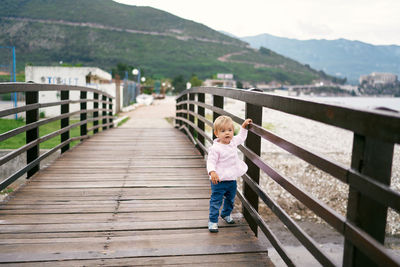 Full length of boy standing on footbridge