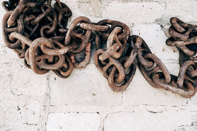 Close-up of rusty chain against wall