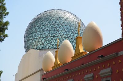 Low angle view of temple against building against clear sky