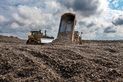 A dumper truck on a large waste management landfill site dumping rubbish in an environmental issue