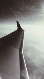 Close-up of airplane wing against sky