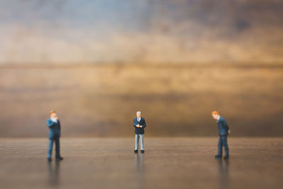 Figurines of businessmen on wooden table