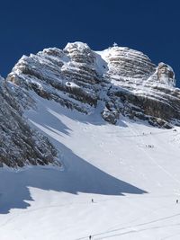 Snow covered mountain against blue sky