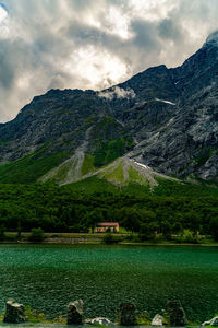 Scenic view of lake by mountains against sky