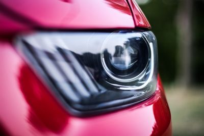 Cropped image of red car headlight