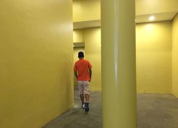 Rear view of man walking in corridor