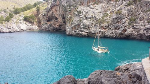 Sailboat sailing on rock by sea