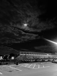 Cars moving on road against cloudy sky