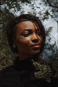 Close-up of young woman looking away in forest