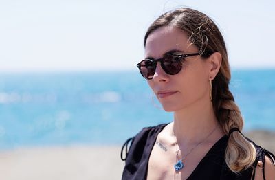 Portrait of woman wearing sunglasses against sea