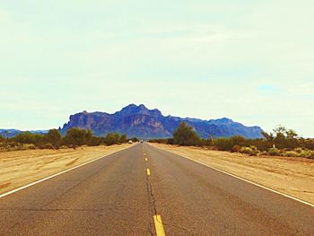 Road by landscape against sky