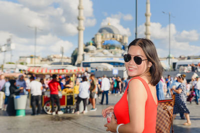 Woman wearing sunglasses against city in background