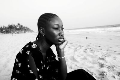 Close-up of young woman looking away sitting at beach