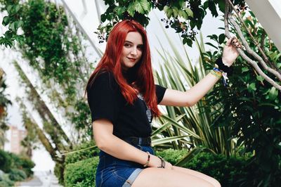 Young woman wearing mask against plants