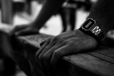 Close-up of hands holding wooden railing