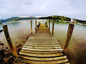 Wooden pier over sea against sky