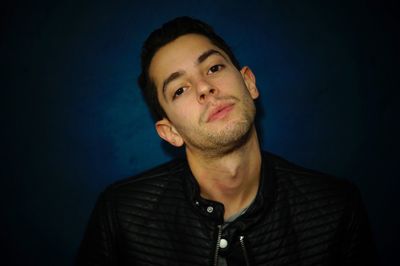 Portrait of young man against black background