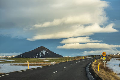 Rear view of man walking on beach against sky