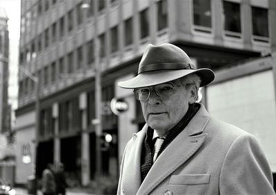 Portrait of man wearing hat in city