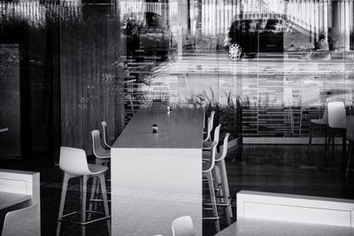 Empty chairs and tables in swimming pool against building