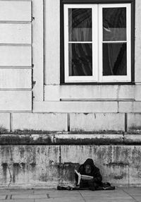 Low section of man with dog sitting at window