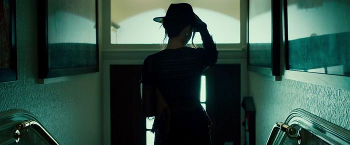 Rear view of woman wearing hat standing at home