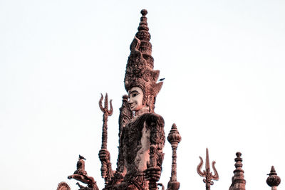 Low angle view of statue against building against clear sky