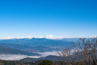 Scenic view of snowcapped mountains against clear blue sky