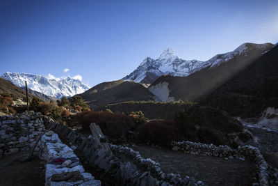 The summit of ama dablam looms over shadows of nepal's khumbu valley.