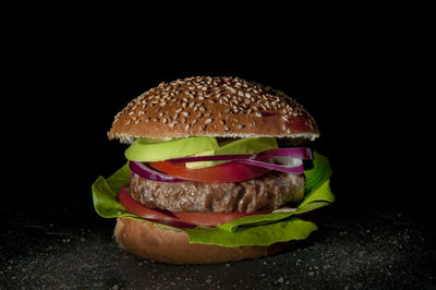 Close-up of burger against black background