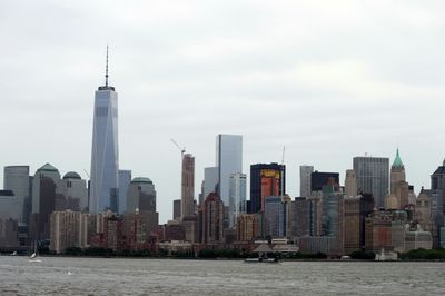 One world trade center by river against sky in city