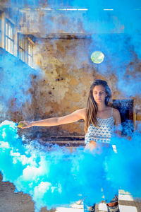 Portrait of young woman holding smoke bomb